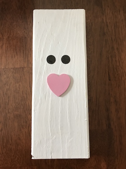 White painted 2x4 to be the bunnies body and adding on the eyes and nose 