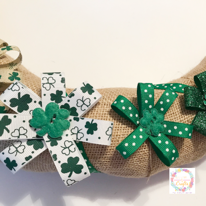 Hot glue on the no sew ribbon flowers with shamrock buttons