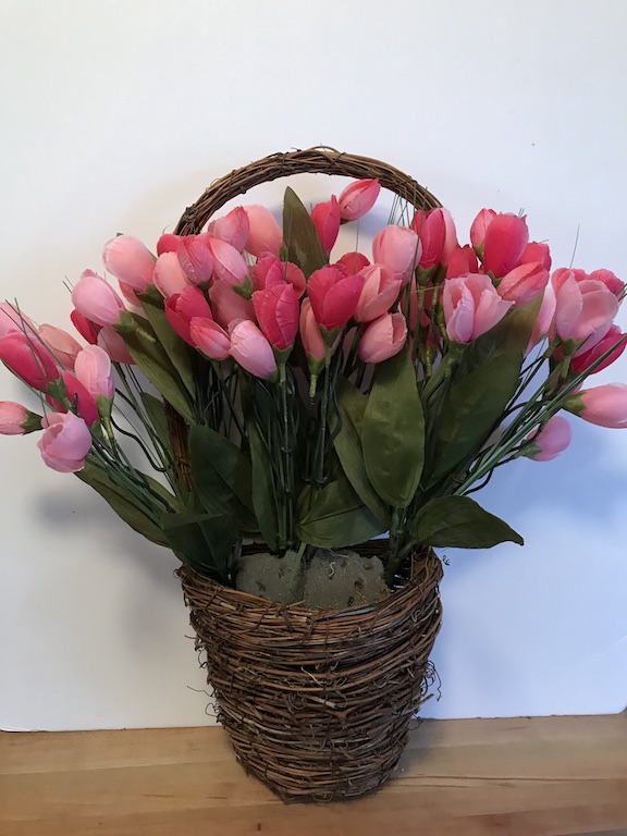 Adding the pink tulip florals to the grapevine basket for an easy DIY Spring Wreath