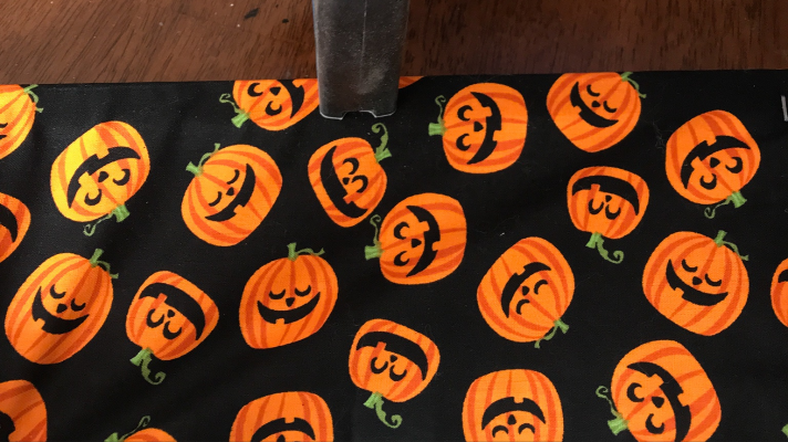 Staple the fabric to the canvas as a Halloween decoration 
