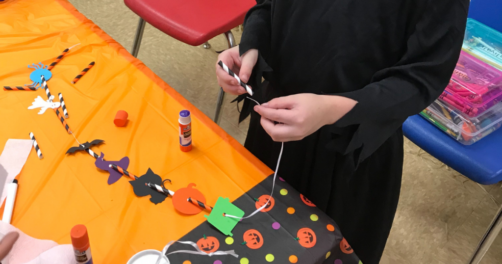String the paper straws onto the ribbon to make a fun and easy Halloween Necklace craft for kids