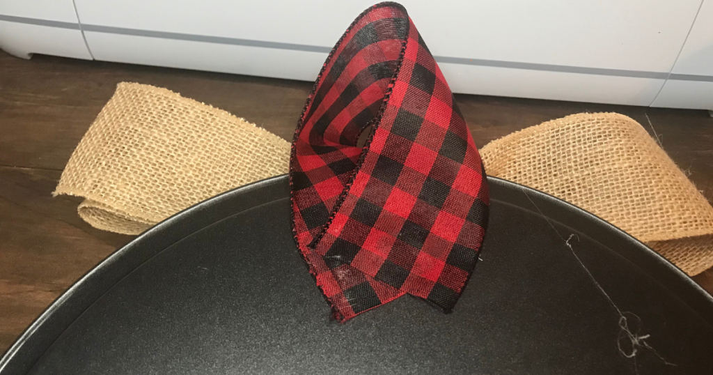 Hot glue ribbon on the back to hang the Christmas pizza pan door hanger or wreath