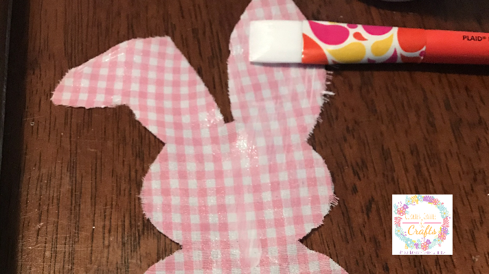 Putting fabric mod podge on the bunny for a DIY bunny Sign 