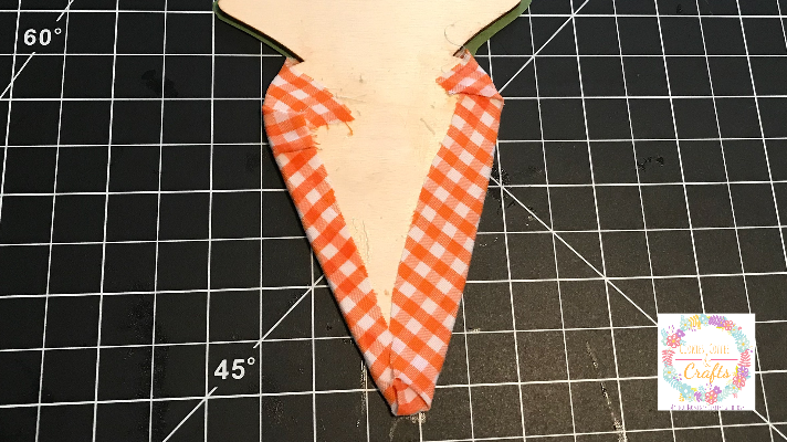 Wrapping the wooden carrot like a present with the fabric 