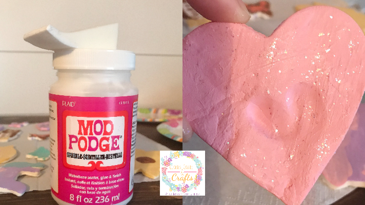 Adding sparkle Mod Podge to the air dry clay magnets