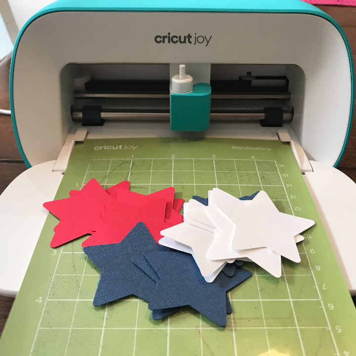 Cricut Joy cutting out the stars for the patriotic paper straw necklaces 
