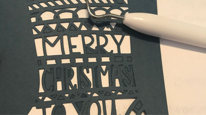 Use the weeding tool to remove some of the small pieces of the Cricut Christmas Card